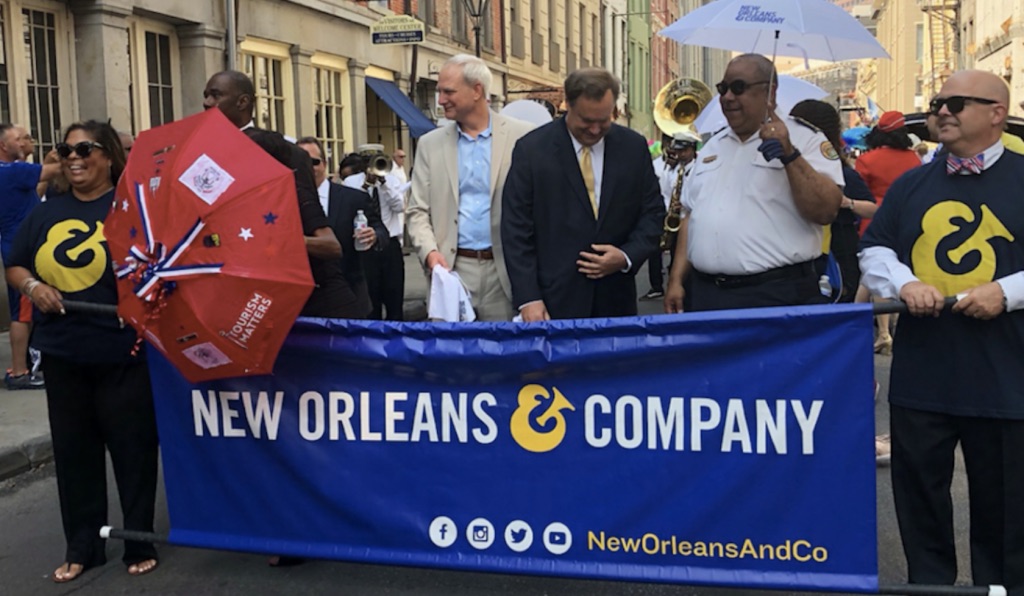 people in french quarter new orleans holding a new orleans and company sign